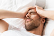 close up of man in bed suffering from headache