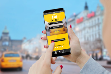 Girl using taxi booking service app on her phone, city street in background