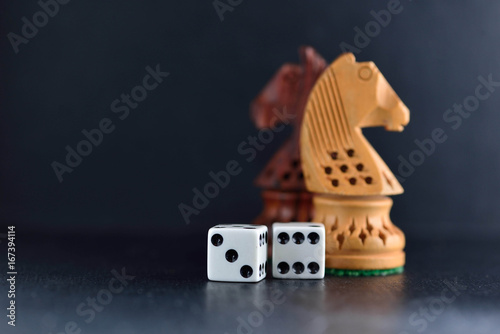 фотография Two white dice and chess knights ob black