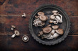 Oyster mushrooms in plate on a dark wooden rustic background. Top view.