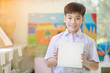 © sirikorn - Happy asian boy hand holding blank paper board and looking at camera