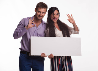 Young happy woman portrait of a confident businesswoman showing presentation, pointing placard gray background. Ideal for banners, registration forms, presentation, landings, presenting concept.