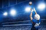 Fototapeta  - American Football Player Catching a touchdown Pass in a large stadium. View from below