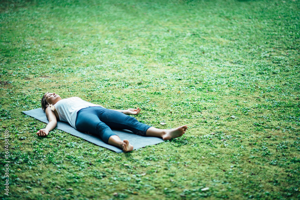 человек расслабленно лежит в шавасане в лесу