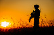 © kaninstudio - Silhouette of military soldier with weapons at sunset. shot, holding gun, colorful sky. military concept.