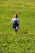 © STphotography - Glückliche rothaarige Frau im Dirndl, läuft lachend durch eine Blumenwiese in den bayrischen Alpen.