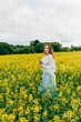 © Денис Кипкаев - Beautiful girl in a dress among yellow flowers in a field