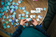 Aerial View Of Child Doing Jigsaw Puzzle