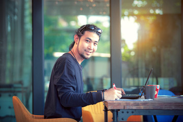 asian freelance man working on computer laptop toothy smiling face