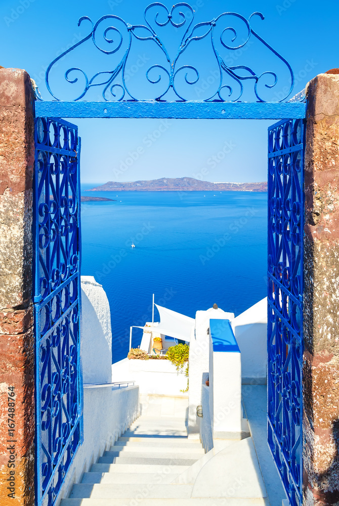 View to the sea and Volcano through door, from Fira the capital of Santorini island in Greece - obrazy, fototapety, plakaty 