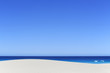 © John White/Stocksy - Blue sky the ocean and a sand dune. Eyre Peninsula.