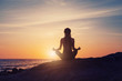 © Annatamila - silhouette of Young woman sitting back, meditate in lotus yoga pose outdoor, on the beach