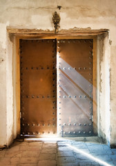 The church door almost close with light rays falling down to the floor, Ananuri fortress church, Georgia. Abstract photo concept of religion, faith, belief and peace.