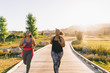 © Cavan Images - Female friends jogging on boardwalk at park
