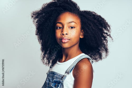 Fotografía Young African with curly hair standing against a gray background