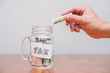 Putting money into a jar labelled tax