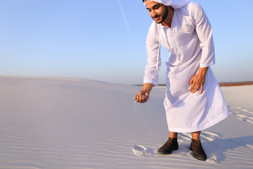 Wall Mural - Muslim man develops sand along wind and standing in middle of de