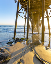 Sunset At The Oceanside Pier In Southern California. Sunset Views Under The Pier On The Beach