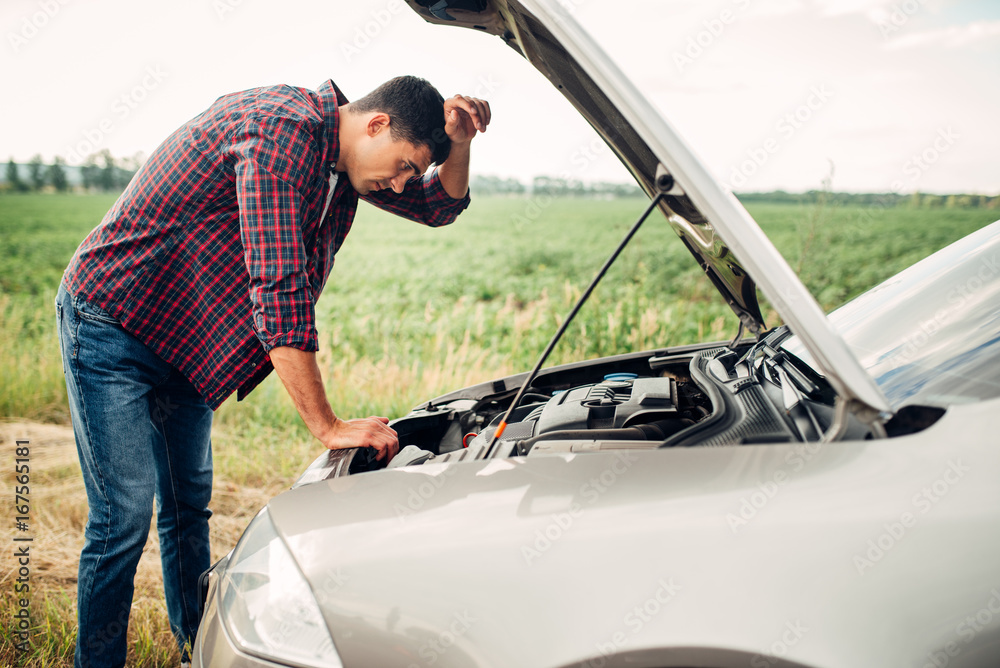 Tired man tries to repair a broken car Stock Photo | Adobe Stock