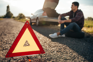 Broken car concept, breakdown triangle on road