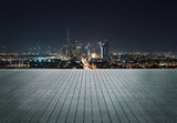 Fototapeta Koty - Wooden terrace with skyline of Dubai at night