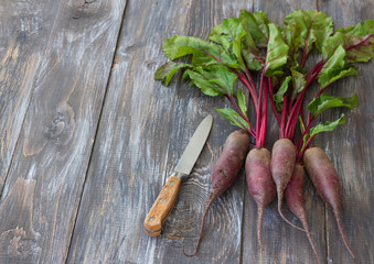 Wall Mural - Fresh organic beetroot with a knife on a wooden surface, top view, selective focus