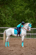 Girl rider trains the horse in the riding course in summer day