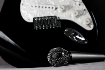 The microphone rests on the electric guitar