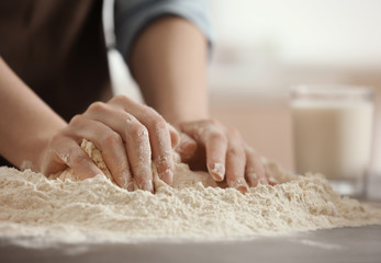 Female chef making dough in kitchen