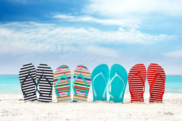 Wall Mural - Colorful flip-flops on sea shore. Summer vacation concept