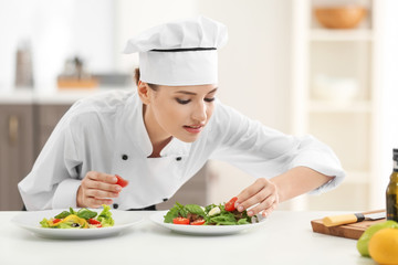 Canvas Print - Young female chef with tasty dishes in kitchen