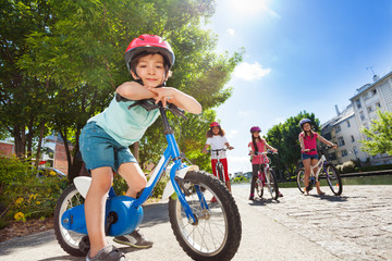 Wall Mural - Happy little cyclist riding bike in summer city