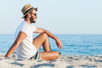 Young hipster man lying on the beach