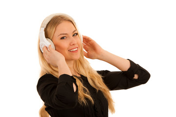 Wall Mural - Beautiful young woman listens to the music on headphones and dance isolated over white background