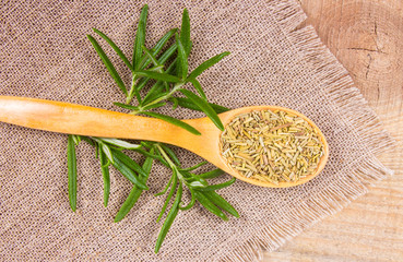 Fresh raw and dry rosemary on rustic background.