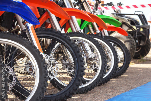 Fotografia, Obraz  Motocross bike stand in a row. Motocross tires and wheels