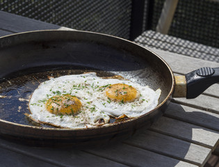 two fried eggs sunny side up egg on old pan on wooden table