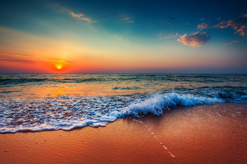 Poster - Beautiful sunrise over the sea and breaking ocean wave
