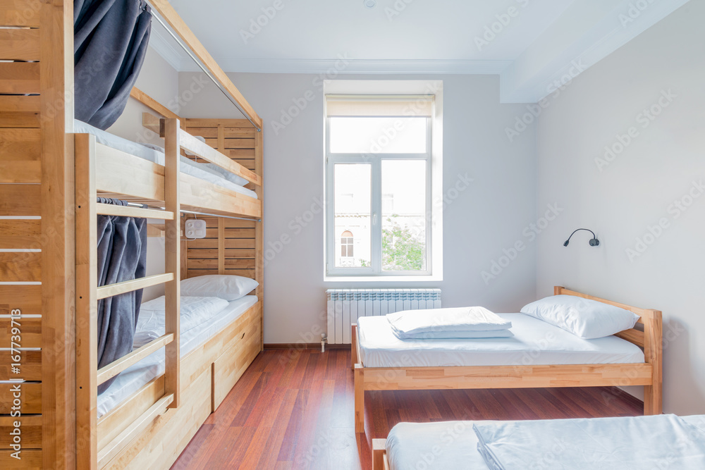Hostel dormitory beds arranged in room - obrazy, fototapety, plakaty 