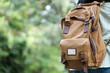 © mangpor2004 - Backpack traveler closeup over green tree nature background with copy space for text, travel and lifestyle concept