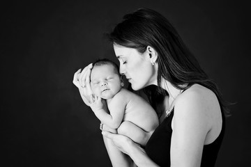 Sticker - Mother kissing and hugging newborn son at gray background, tender, care, love