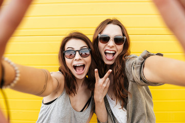 Poster - Happy women friends standing over yellow wall