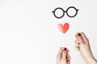 female hand holding glasses and heart photo booth prop