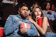 Young scared couple watching a horror movie
