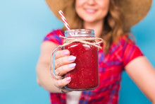 Smiling Woman Drink Red Juice. Studio Portrait With Blue Background And Copy Space