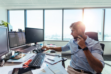 Wall Mural - Business investor sitting at his desk in office.