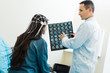 © Viacheslav Yakobchuk - Doctor showing CT scan results to patient undergoing electroencephalography