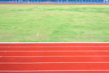 Red Running Track In Stadium With Field Grass