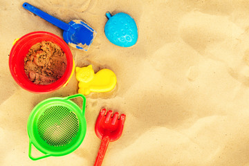 colorful beach toys on sand with copy space