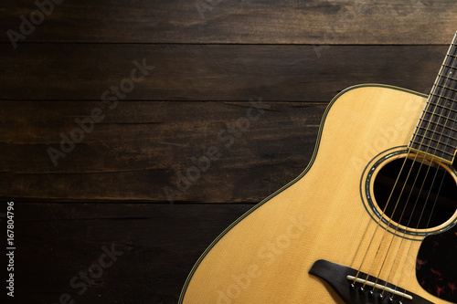 Plakat Gitara akustyczna odpoczywa przeciw drewnianemu tłu